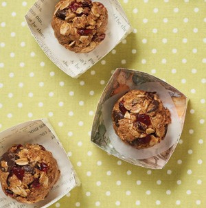 Dried cherry and chocolate no bake balls in paper on yellow and white polka dot backdrop 