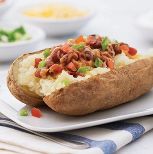 Baked russet potato topped with chopped bacon and chives