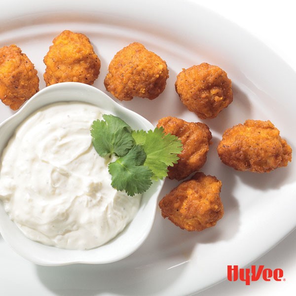 Plate of baked popcorn chicken served with a side of ranch
