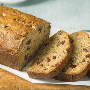 Sliced loaf of zucchini pineapple bread on parchment paper