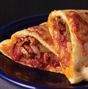 Plate of calzones filled with Italian sausage, pizza sauce, onions and red and green peppers