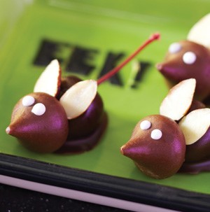 Hershey Kiss attached to chocolate-covered maraschino cherry, decorated with almonds and frosting