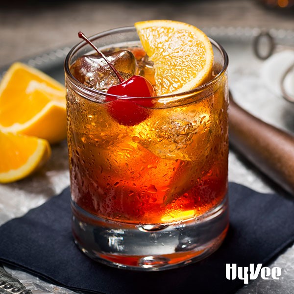 Old fashioned in glass with a cherry and orange wedge