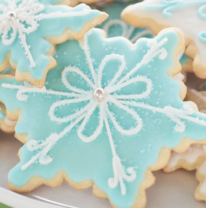 Snowflake-shaped sugar cookies topped with blue and white icing