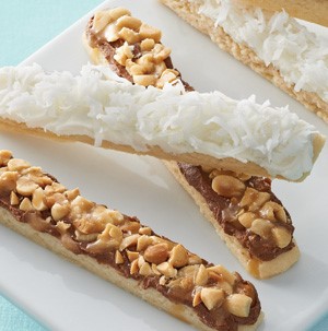 Short bread sticks with chocolate and nuts and vanilla frosting with shredded coconut