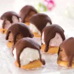 Cookies topped with ice cream scoop and melted chocolate