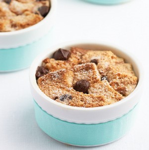 Bread pudding in a blue bowl with chocolate chips on top