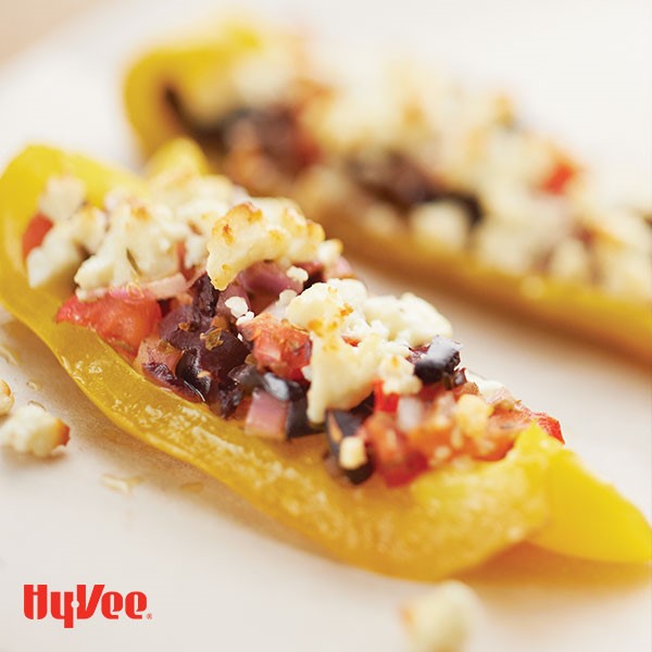 Wedged yellow bell peppers filled with chopped tomatoes, black olives, and cheese