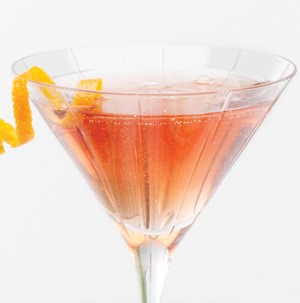 Sparkling cranberry martini garnished with a citrus peel