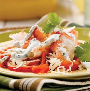 Tortilla topped with Alaska crab meat, red bell peppers, cheese, cilantro and sour cream
