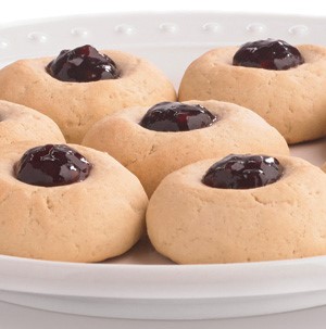Thumbprint cookies filled with jam on a white plate
