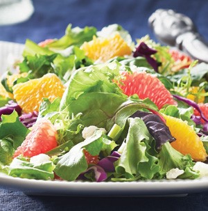 Mixed greens with orange segments and crumbled cheese