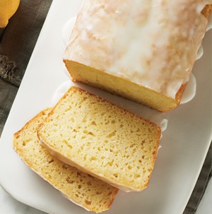 Sliced lemon bread loaf with white icing  on a white plate