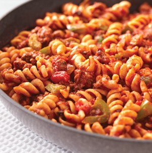 Spiral noodles topped with red sauce, ground meat, and sliced green olives