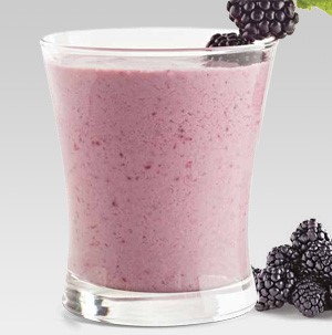 Glass filled with pink blackberry smoothie, garnished with fresh blackberries