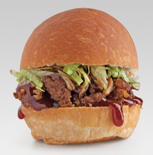 Bun topped with ground meat, sauce, lettuce, and onions