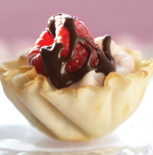 Filo dough pastry cup filled with raspberry cream and topped with whole raspberry and chocolate glaze