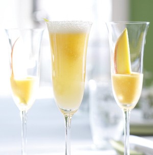 Glass flutes filled with bellini mocktails and sliced apricot