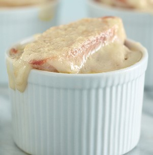 White stripped ramekin topped with bread slice and melted white cheese