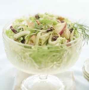 Bowl of apple-fennel slaw garnished with fennel sprigs