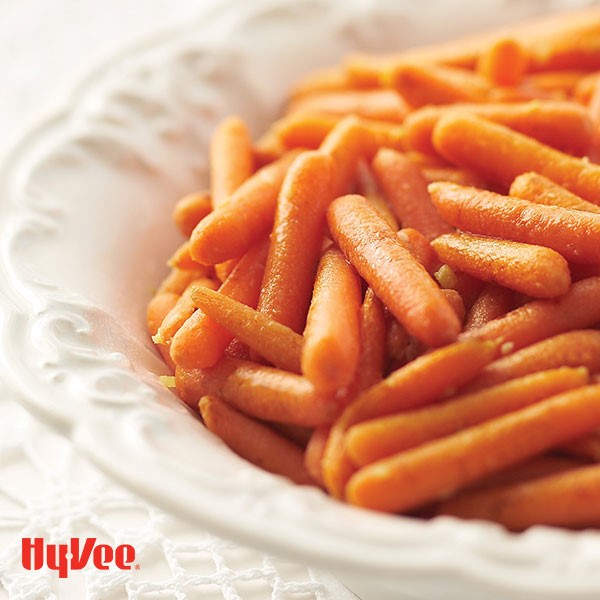 White serving platter filled with ginger glazed baby carrots