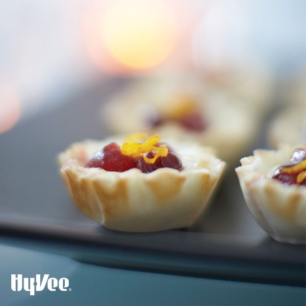 Tray of cranberry-orange brie cups, garnished with orange zest