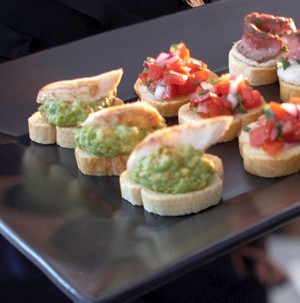 Platter of crostini with avocado spread and roasted chicken