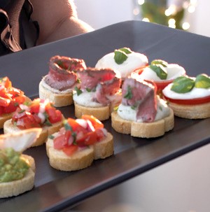 Platter of crostini with white bean spread and beef tenderloin