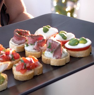 Black serving platter topped with mini crostinis 