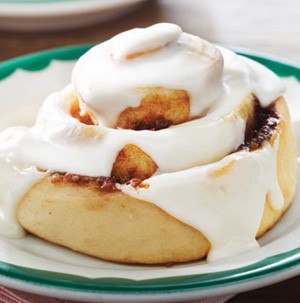 Plate of cinnamon rolls topped with white icing