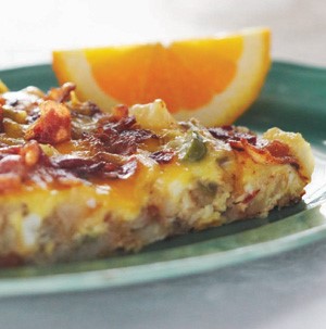 Egg breakfast skillet on a teal plate with orange wedge