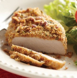 Pecan-and-herb crusted pork chops on white plate with side salad