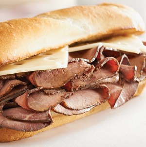 Sub bun holding roast beef and slices of swiss cheese