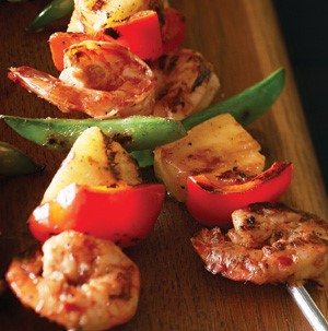 Shrimp, red bell pepper, pineapple and sugar snap peas on metal skewers