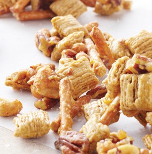 A combination of cereal, pretzel sticks, peanuts and pecans 