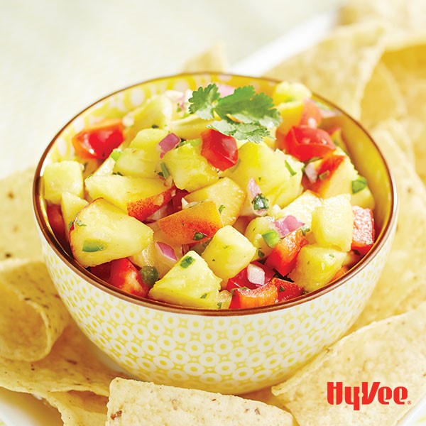 Cup of pineapple salsa served with tortilla chips