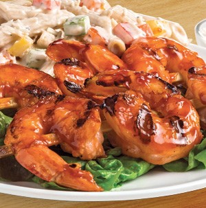 BBQ shrimp over plate of pasta salad