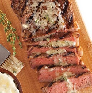 Brisket brushed with blue cheese-thyme butter sauce on a wooden board