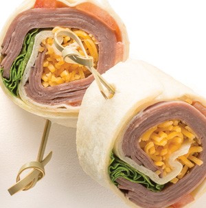 Tortillas wrapped around lettuce, shredded cheese, and corned beef