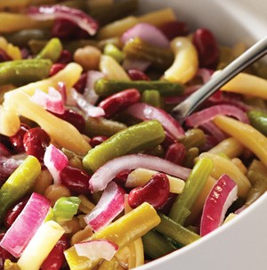 White and green beans in a bowl with sliced red onions