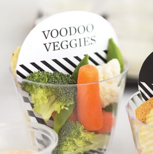 Clear veggie cups with baby carrots, broccoli, and cauliflower with a white sign on top