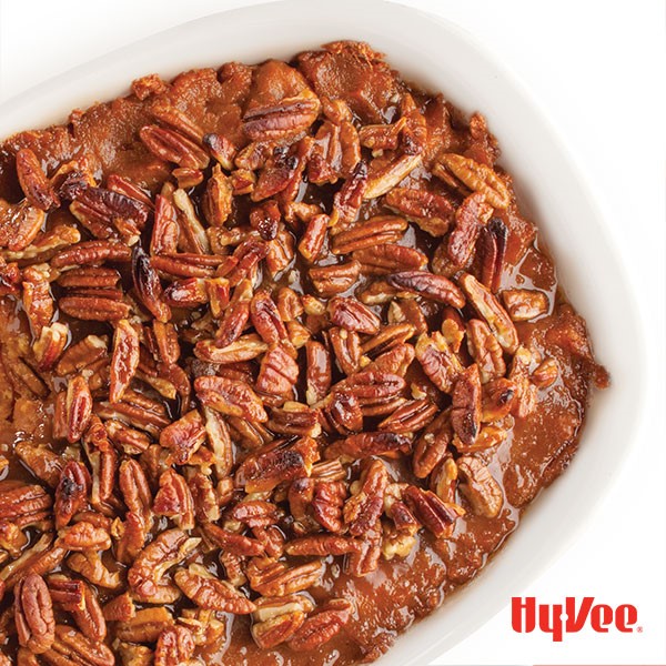 Casserole dish of sweet potato puree, topped with toasted pecans