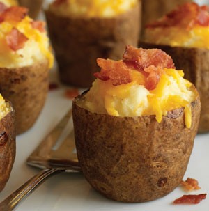 Potato halves filled with potato filling, topped with cheese and chopped cooked bacon