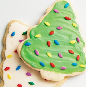 Sugar cookie tree cut out cookies with white and green frosting and multi colored sprinkles