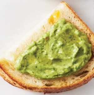 Avocado spread on a slice of jalapeno-cheddar bread