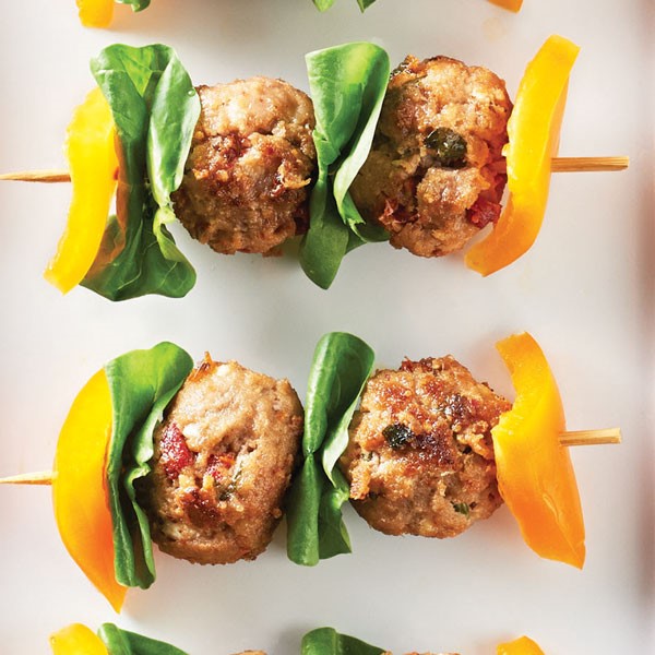 Yellow bell pepper, spinach, and meatballs on wooden skewers