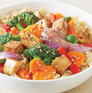 Chicken and vegetables stir-fried over a bowl of cooked quinoa