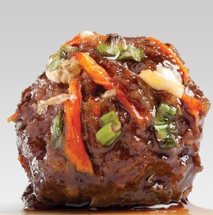 Teriyaki glazed meatball topped with fresh shredded carrots and sliced green onions