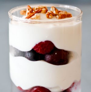 Glass layered with fruit, Greek yogurt, and chopped pecans