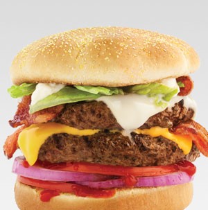 Bun topped with sliced red onion, tomatoes, two burger patties, cheeses, and lettuce